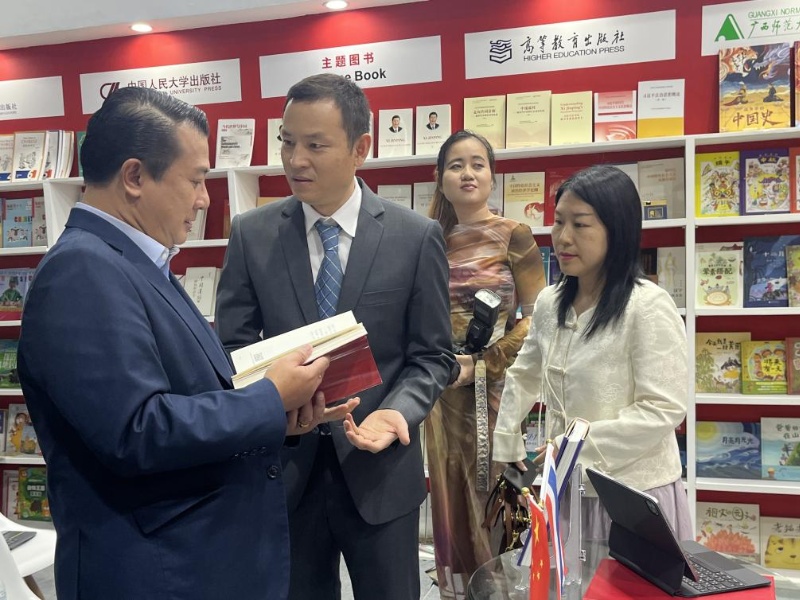 泰國書(shū)商和出版商協(xié)會(huì )主席蘇維奇（左一）在翻閱《近鏡頭：溫暖的瞬間》。（盧雯 攝）jpg_副本.jpg