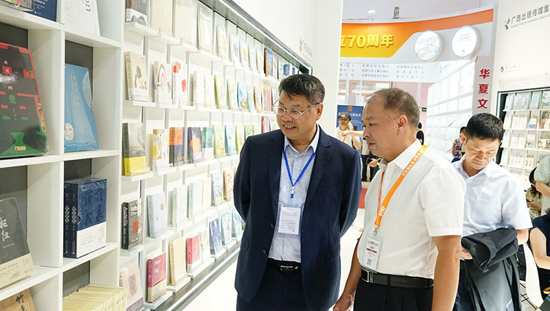 集團公司黨委書(shū)記、董事長(cháng)張藝兵向校黨委副書(shū)記趙鐵詳細介紹出版社圖書(shū)（陳子鋒攝）.JPG